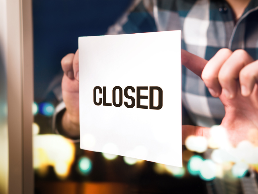 扉にCLOSEDという張り紙を貼っている