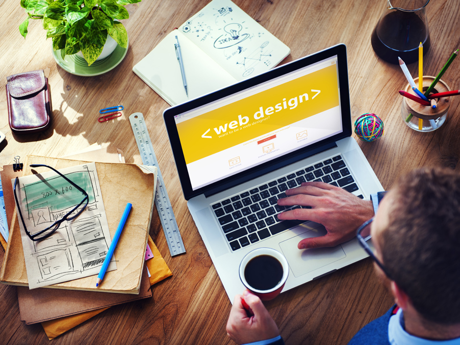 デスクでwebdesignをする男性の画像